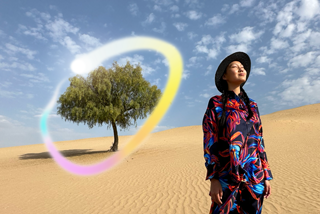 iPad Pro, écran face avant avec fond dégradé bleu foncé et vert et plusieurs apps ouvertes, main tenant un Apple Pencil Pro encerclant un croquis et illustrant la fonctionnalité baguette graphique d’Apple Intelligence